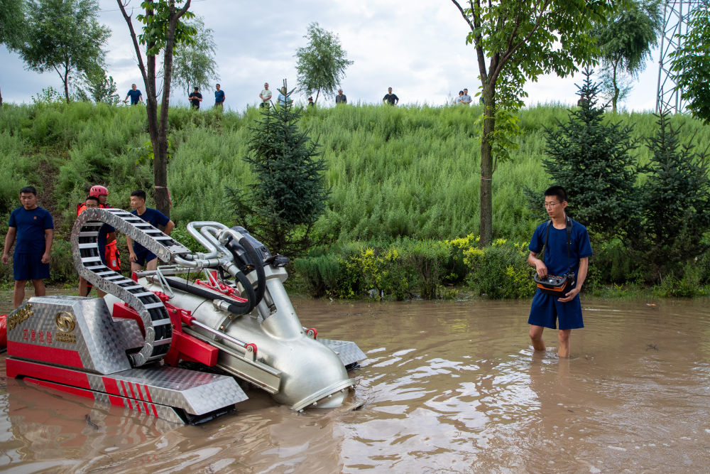 8月5日，在牡丹江市东安区大湾村附近，牡丹江市消防救援支队的消防员操控机器进行排涝。新华社记者 张涛 摄