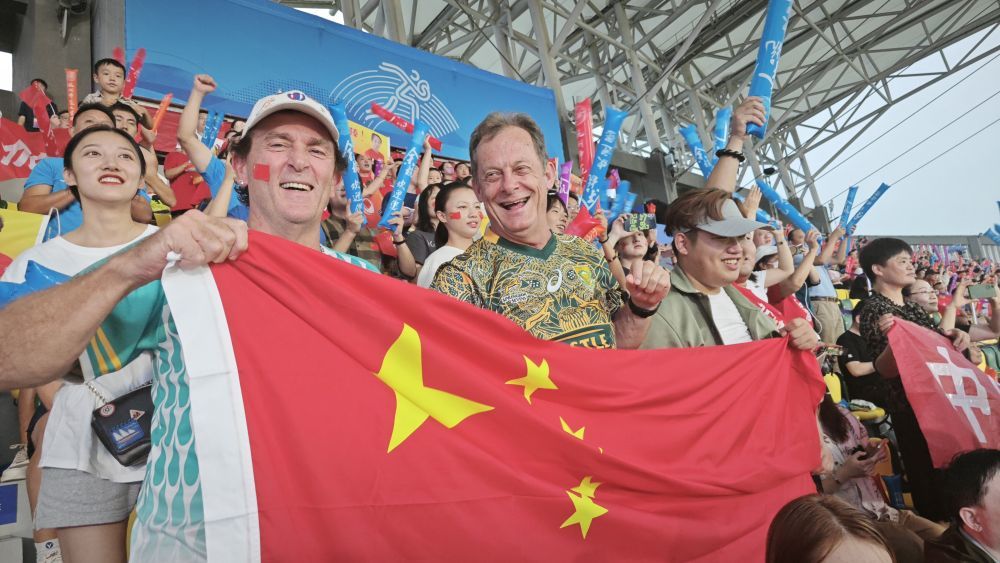 埃里克（左）和本展示五星红旗，为中国队加油
