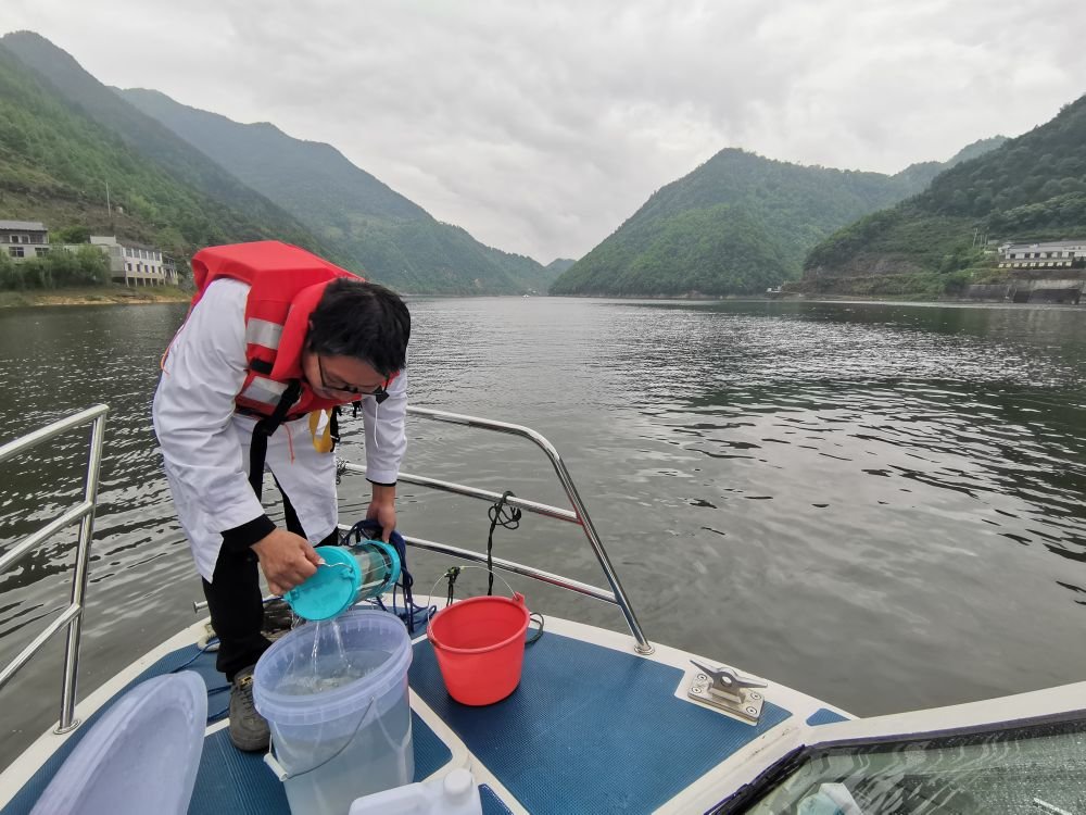 图为5月24日，生态环保工作者在新安江皖浙两省交界处，把从新安江中取出的水样倒进桶里。 新华社记者刘方强 摄