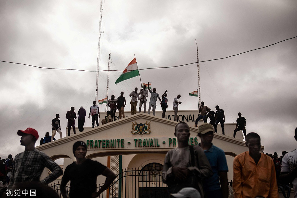 当地时间2023年8月3日，尼日尔尼亚美，抗议者在示威活动中举着尼日尔国旗。8月3日，数百名支持尼日尔政变的人聚集在首都尼亚美举行大规模集会。