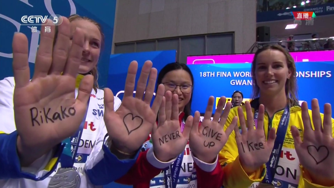 · 3位游泳选手在手心写着“Never give up”。