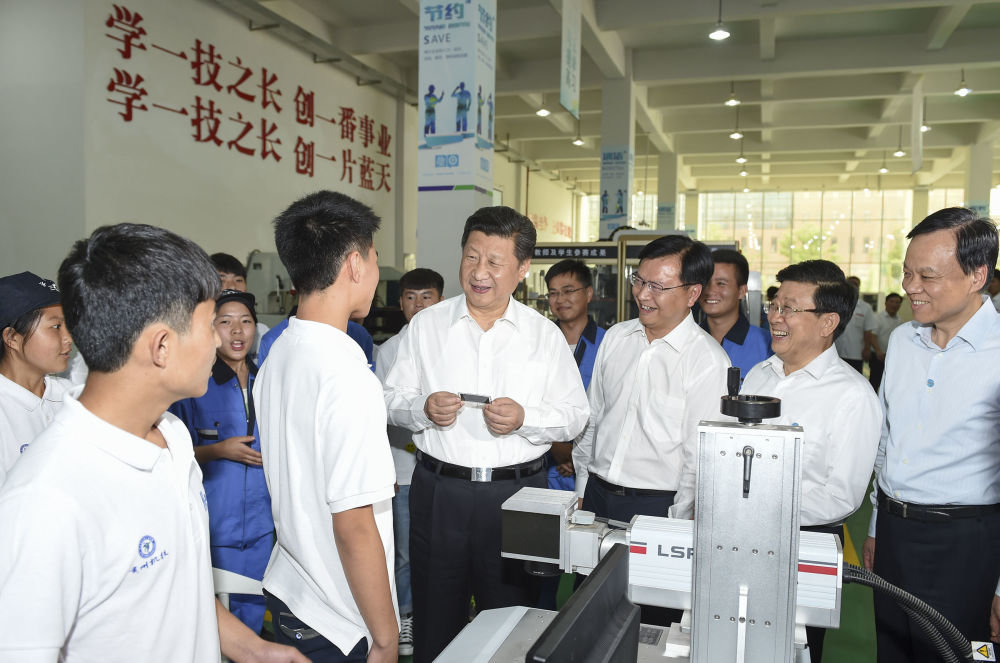 2015年6月17日，习近平在贵州省机械工业学校实训基地勉励学生加强操作训练、不断取得优异成绩。