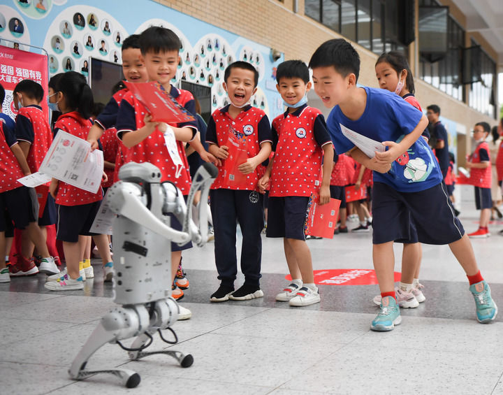 在湖南长沙华夏实验学校举办“科技大篷车”进校园活动上，学生们在和机器狗互动（2022年6月22日摄）。新华社记者 薛宇舸 摄