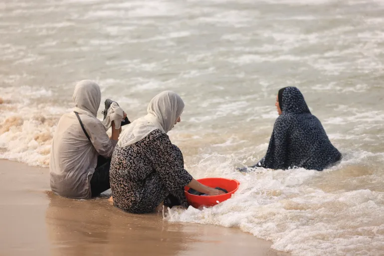 ◆由于缺乏淡水和电力，巴勒斯坦妇女在加沙地带南部代尔巴拉赫的海里洗衣服。