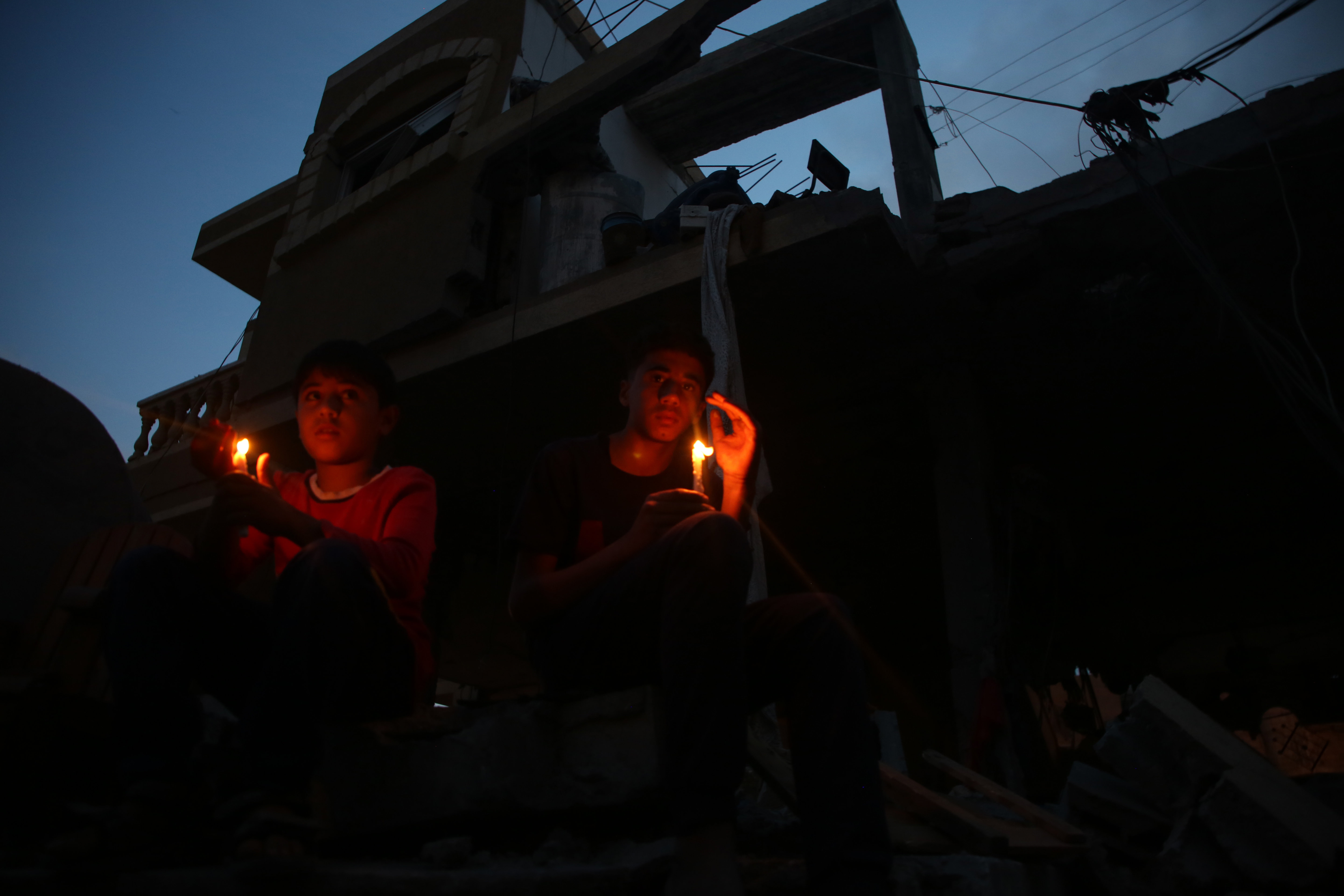 巴以达成停火协议儿童在房屋废墟上点燃蜡烛