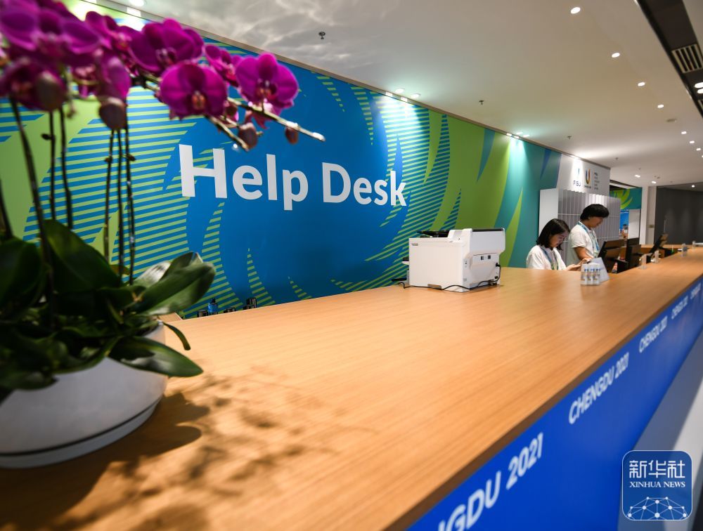 ↑7月13日,在成都大运会主媒体中心,工作人员正在服务台工作。 新华社记者 王曦 摄