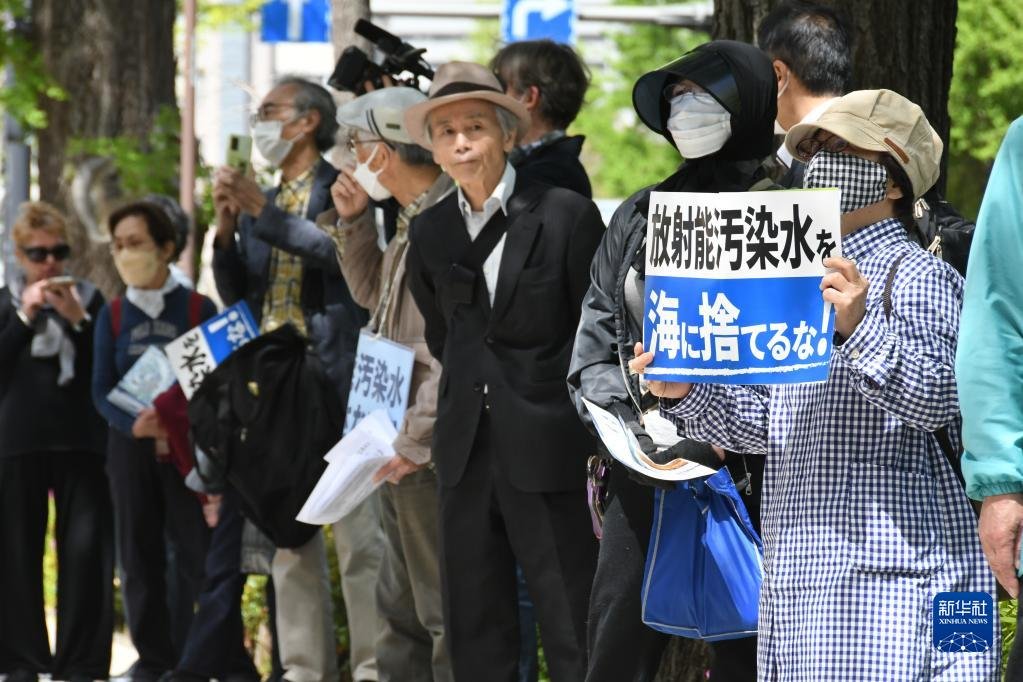 4月13日，在日本东京，民众手举标语在日本国会众议院第二议员会馆前参加集会抗议。新华社记者 岳晨星 摄