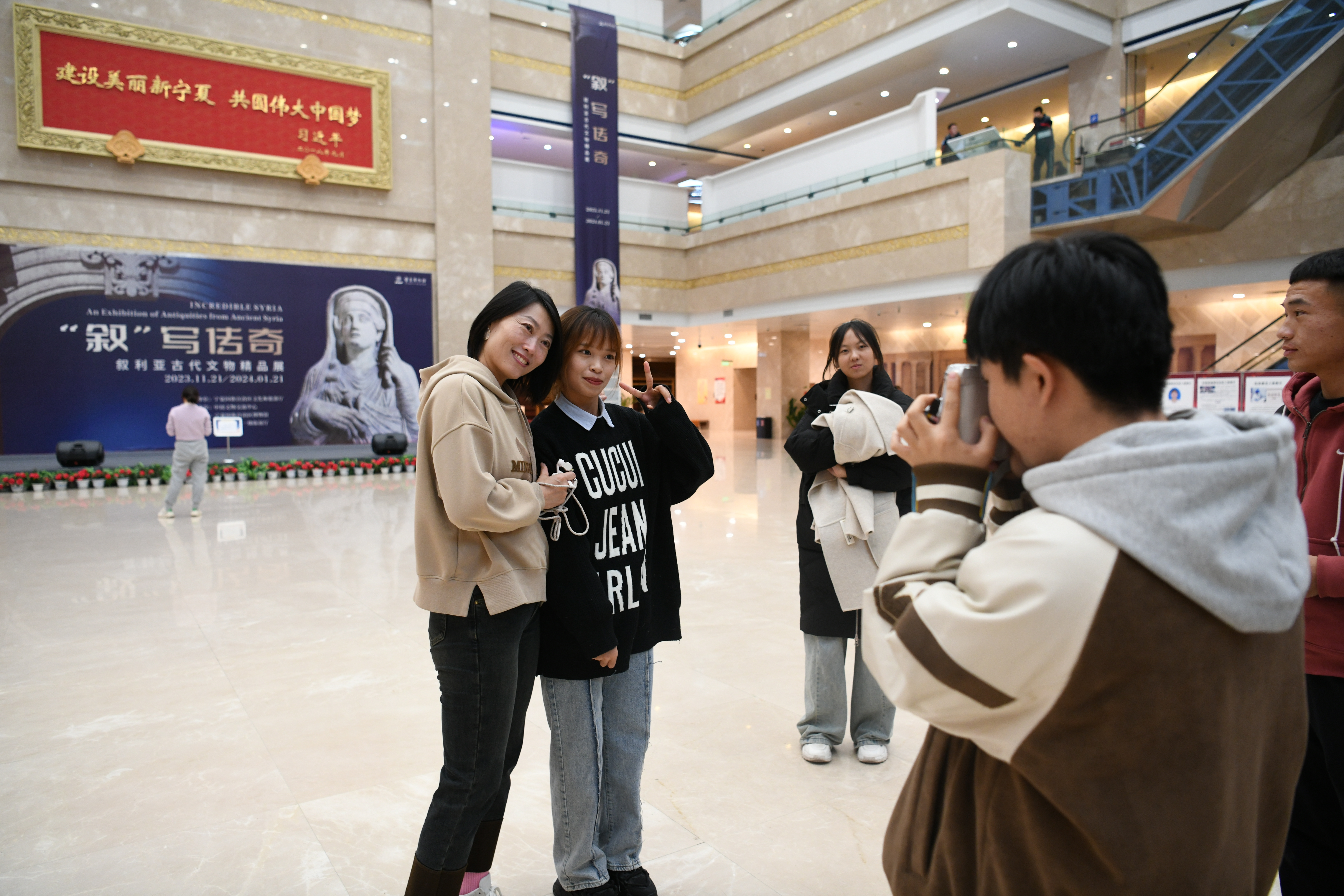 游客们对这场跨越时空的展览充满期待,纷纷在展厅海报前合影留念。