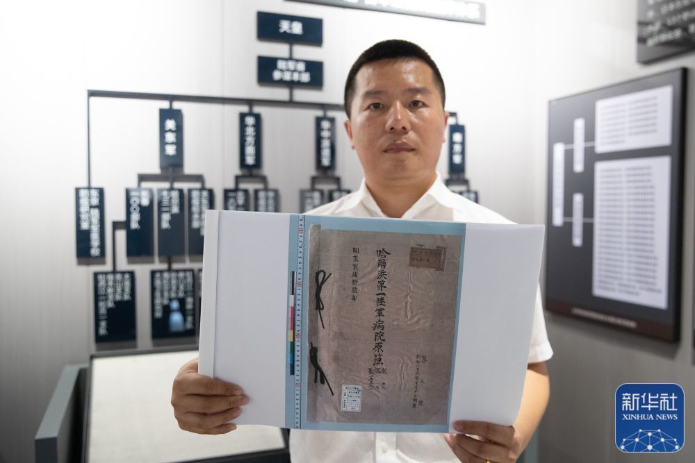 8月5日，在黑龙江省牡丹江市举办的侵华日军细菌战罪证陈列展上，研究人员展示《日军哈尔滨第一陆军病院原簿》（影印件）。