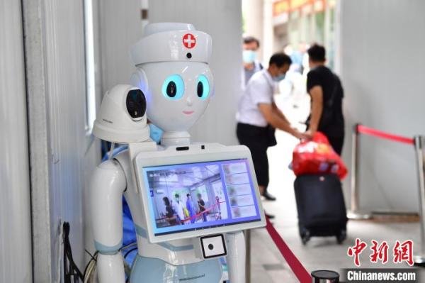 人工智能机器人正在对进入医院的患者和家属测量体温,高效的操作避免了人员滞留