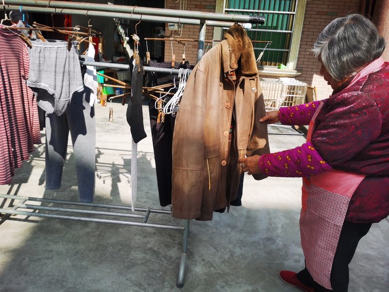 李彩英家的院子里晾满了她为阿才洗的衣服。