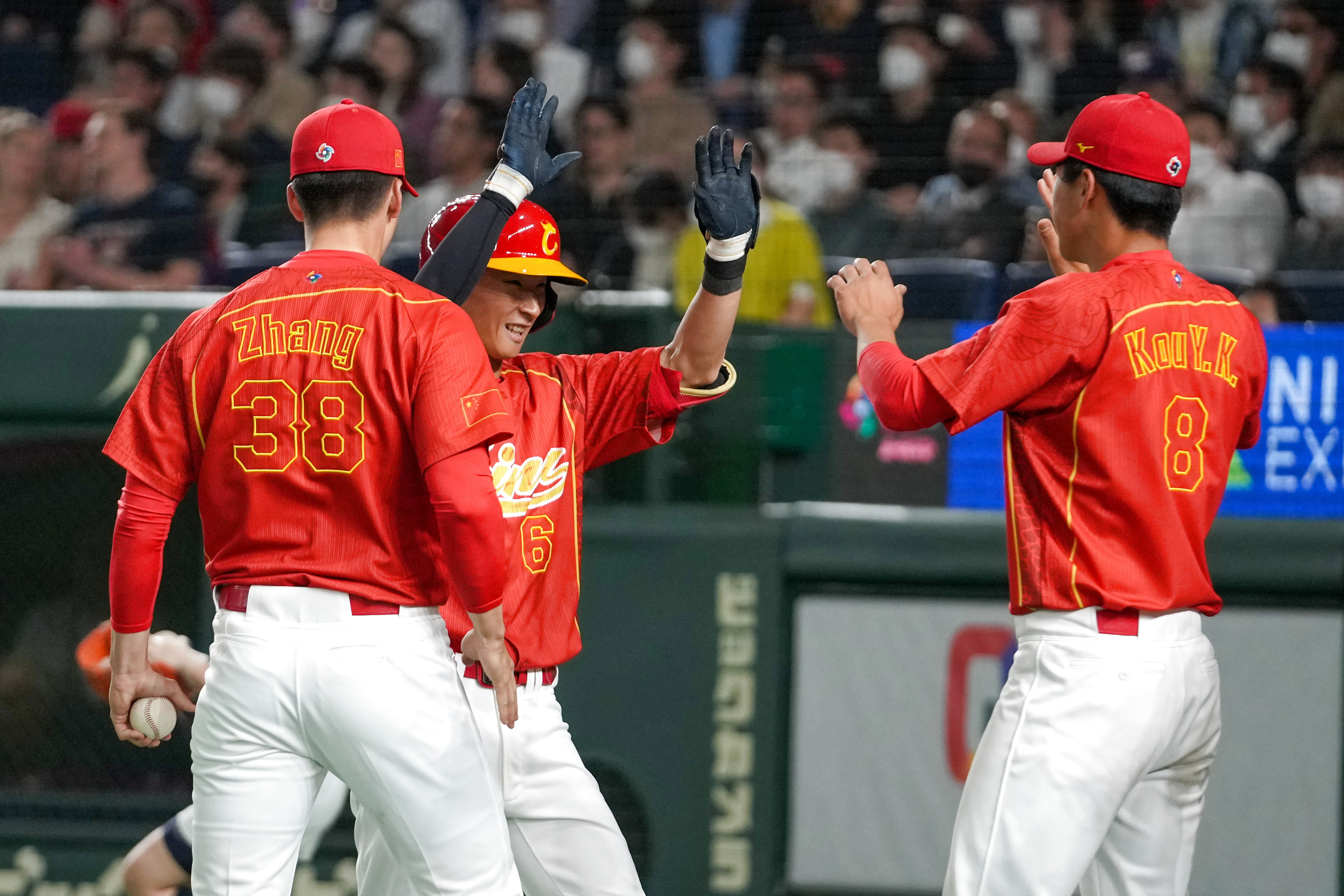 3月9日，中国队选手梁培（中）打出全垒打后和队友庆祝。新华社记者 张笑宇 摄