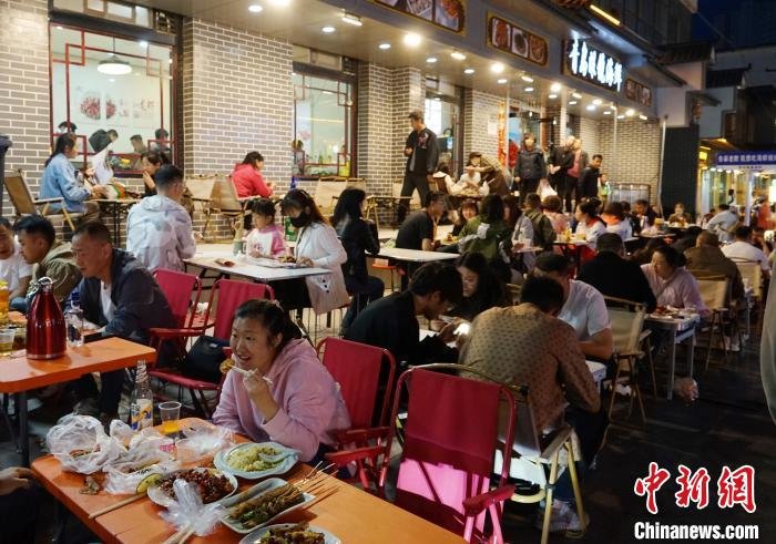 图为游客在西宁市城中区大新街夜市品尝美食。 马铭言 摄