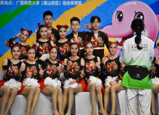 学青会志愿者“小青芒”正在给啦啦操比赛候分的运动员留影。新华社记者 郑昕 摄