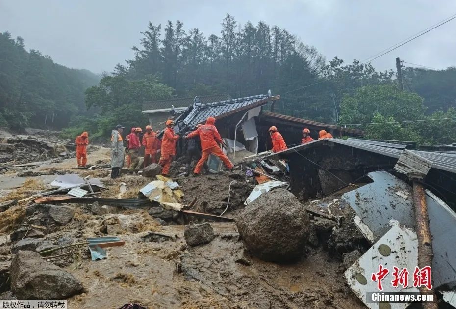 圖為韓國榮州，救援人員在因大雨引發(fā)山體滑坡而倒塌的房屋中搜尋失蹤人員。