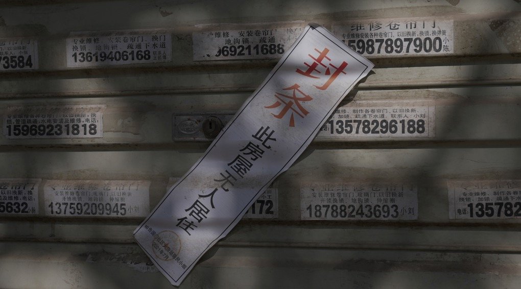 1月6日,云南省德宏州瑞丽市姐告国门社区沿街商铺大多仍关着门,许多卷帘门上依然贴着疫情期间的封条。