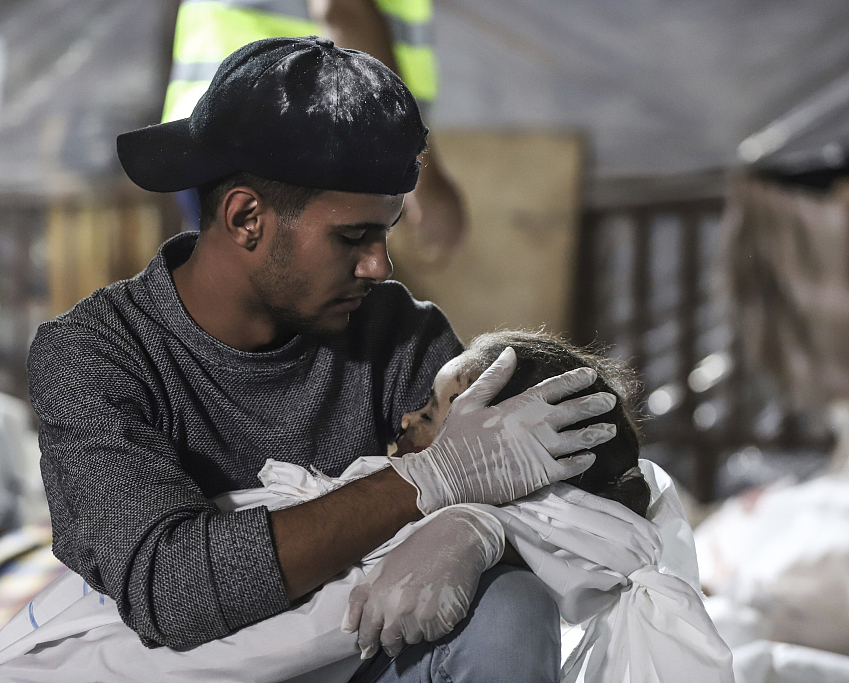 当地时间2023年10月17日，以色列对加沙发动空袭后，一名男子抱着丧生的儿童。
