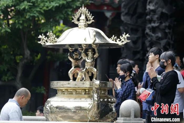 资料图：台北龙山寺内，信众有的持一柱香祈福，有的双手合掌行礼。中新社记者 陈小愿 摄
