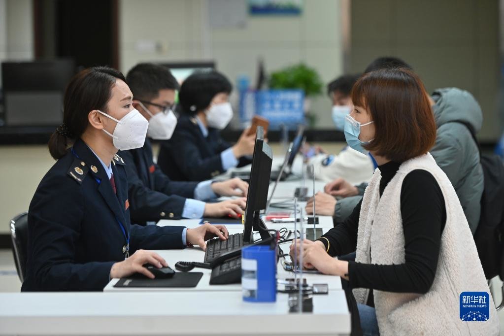 在福州市闽清县办税服务大厅,工作人员向企业工作人员介绍税惠政策(2023年2月13日摄)。新华社记者 周义 摄