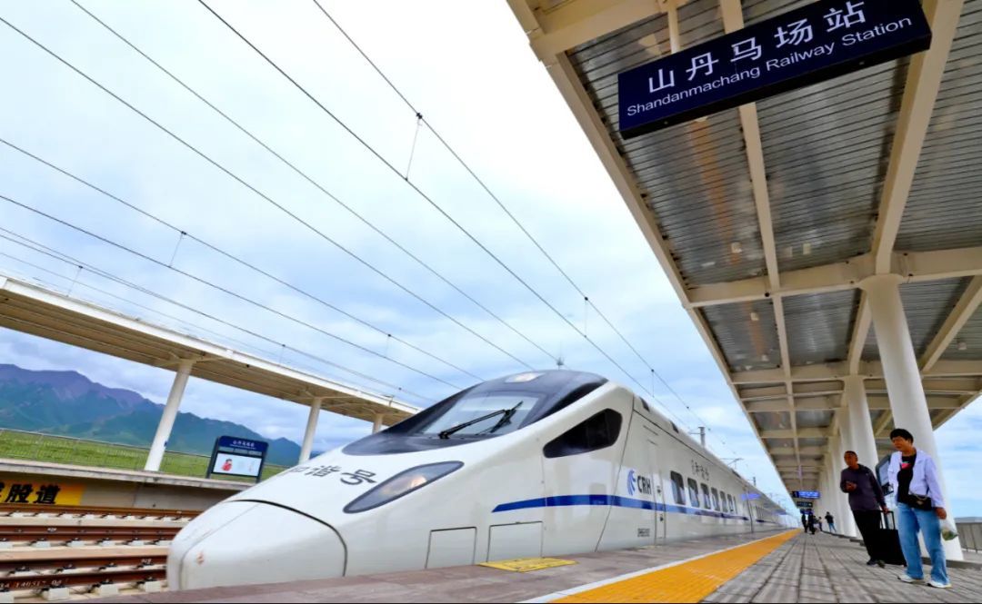 7月1日，甘肃张掖市，由张掖西驶往西安北的D2682动车驶入兰新高铁山丹马场站，游客正在准备乘车。图/视觉中国