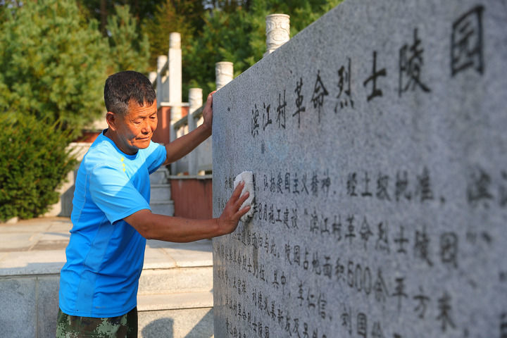 ↑在辽宁省丹东市振兴区滨江村，村民擦拭滨江村革命烈士陵园石碑（2022年9月26日摄）。新华社记者 杨青 摄