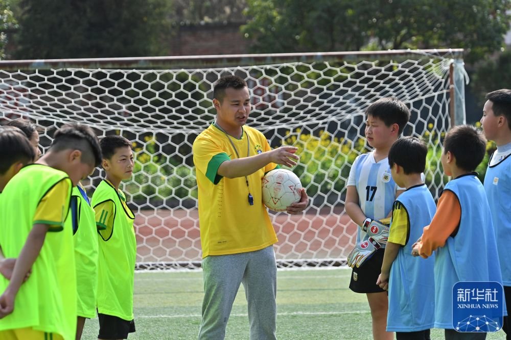 3月15日,老师在上塘镇中心小学足球场指导学生们练习足球.
