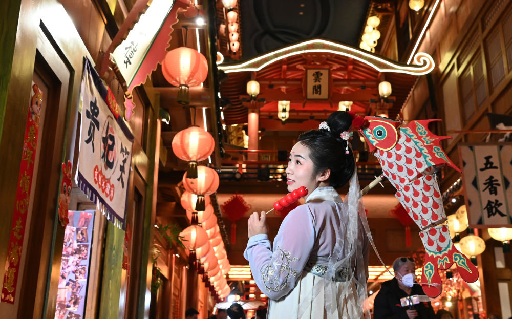 1月24日，身穿汉服的游客在西安“长安十二时辰”主题街区里游玩拍照。新华社记者 刘潇 摄