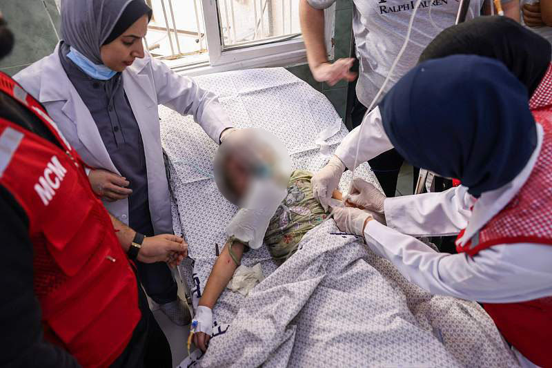 △当地时间13日，巴勒斯坦加沙地带南部拉法，医务人员照料一名在以军空袭中受伤的儿童。
