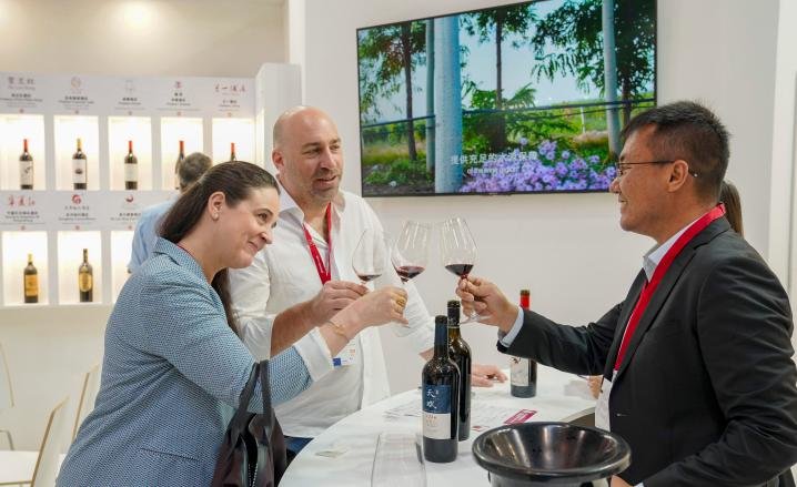 2022年5月15日，参会者（左）在德国杜塞尔多夫国际葡萄酒与烈酒展览会上品鉴宁夏贺兰山东麓葡萄酒。新华社发