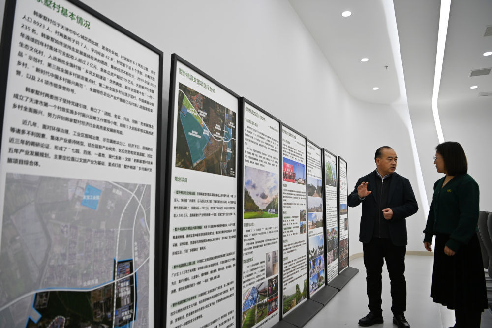 12月21日，胡震刚（左）在给客人介绍韩家墅村基本情况。新华社记者 李然 摄