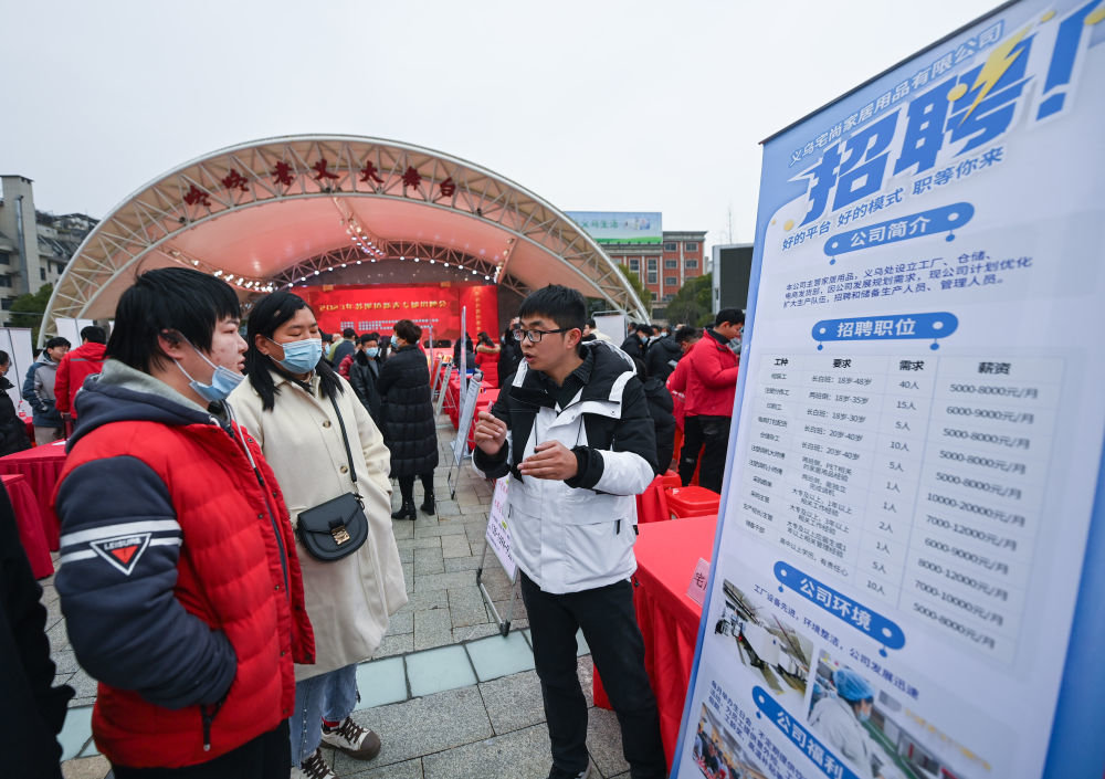2月4日，求职者在招聘会现场与企业工作人员（右一）交谈。当日是立春，浙江省义乌市苏溪镇开启“百企千岗”新春首场招聘会。新华社记者 徐昱 摄