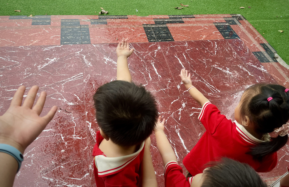 〓 2023年6月下旬的育彤幼儿园，孩子们站在门口感受夏天的风和雨。摄：张楠茜