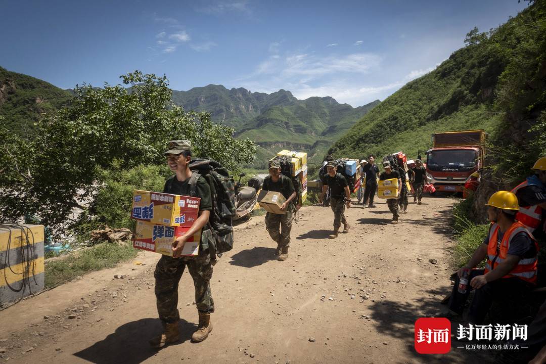 8月5日，支援救灾的解放军战士徒步往村内运送物资。拍摄：杨峰