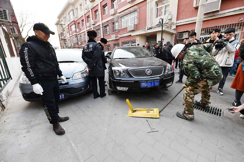 在海淀学院南路32号院内,工作人员集中拆除地锁。本报记者 饶强摄