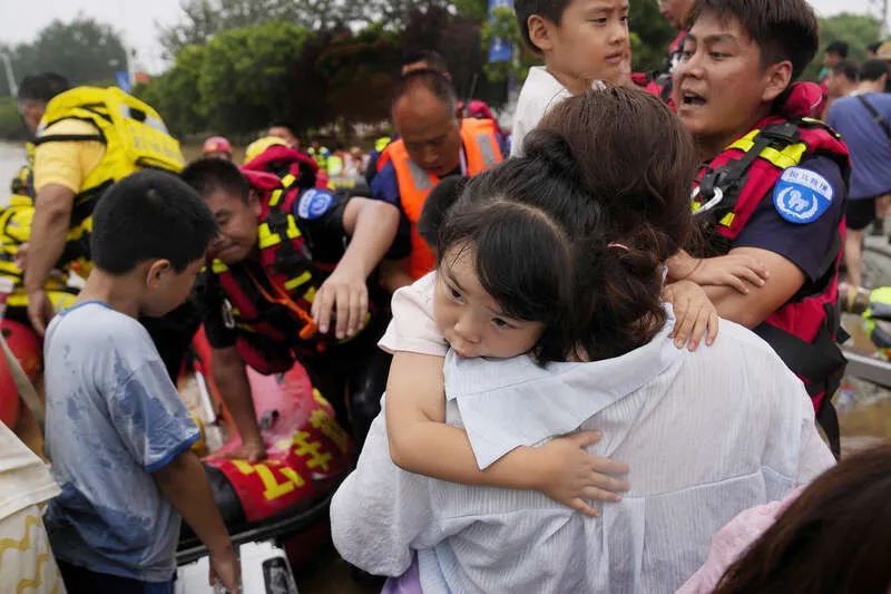 8月2日，河北涿州，救援人员帮助被困居民乘坐橡皮艇从洪水中撤离。视觉中国供图