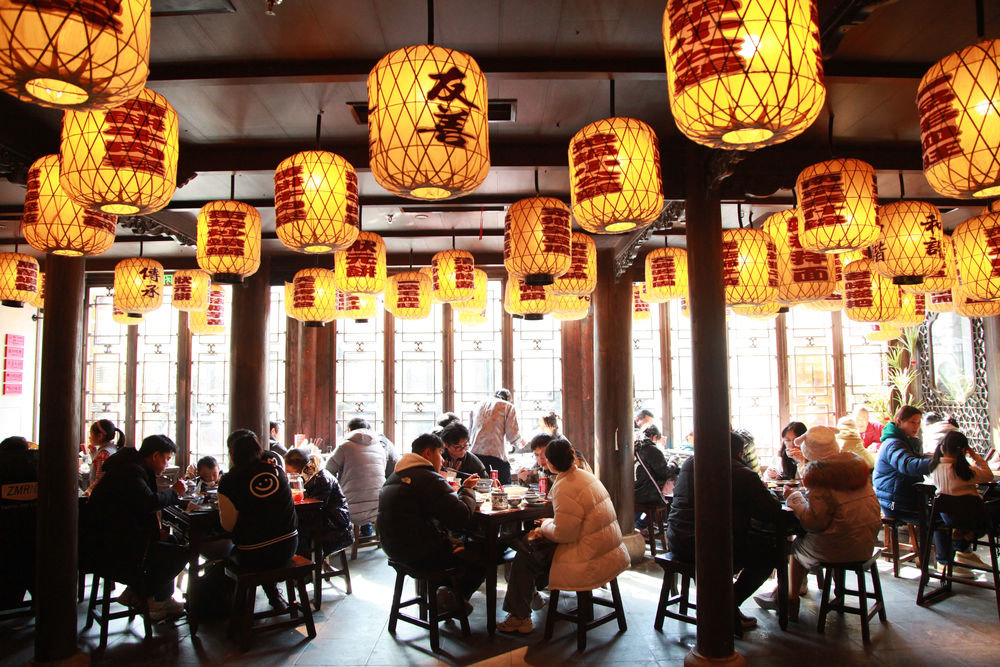 ↑1月24日，顾客在南京老门东的一家餐厅品尝金陵风味美食。新华社发（刘建华 摄）