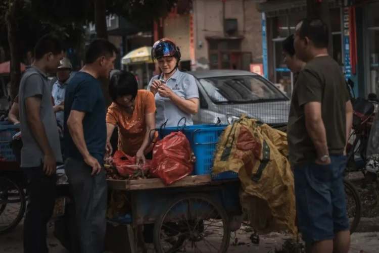 △高州卖荔枝的摊贩。/图虫创意