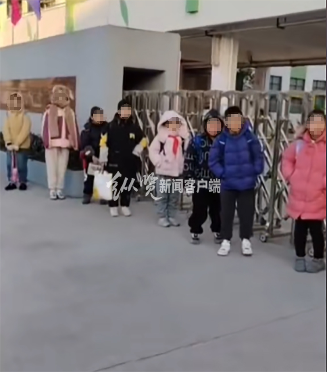 家长拍摄的视频中多名小学生正在校门口排队等待。（来源/视频截图）
