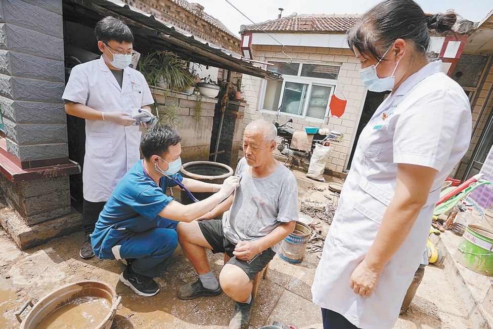 8月8日，门头沟区妙峰山镇卫生院与北京友谊医院驰援团队的医护人员，对村民进行巡诊和防疫宣传。本报记者 方非摄