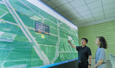 山东省邹平市明集镇，农业技术人员通过农业智慧平台查看“数字农田”监管和服务系统在农田的分布使用情况。