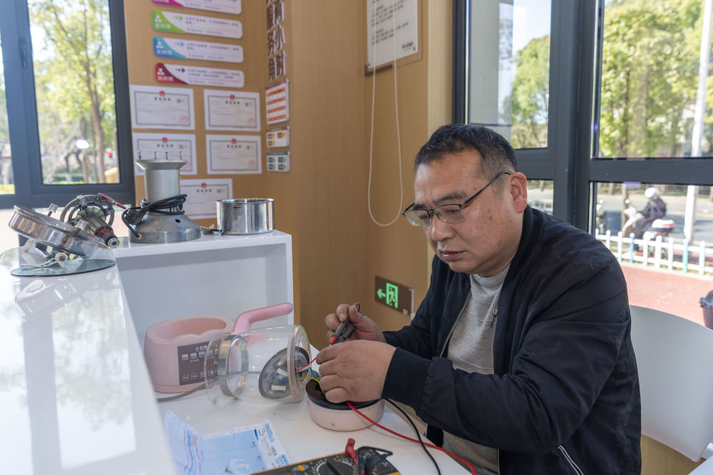 3月14日，上海市松江区中山幸福里社区的维修师傅张辉在为居民修理小家电。新华社记者 王翔 摄