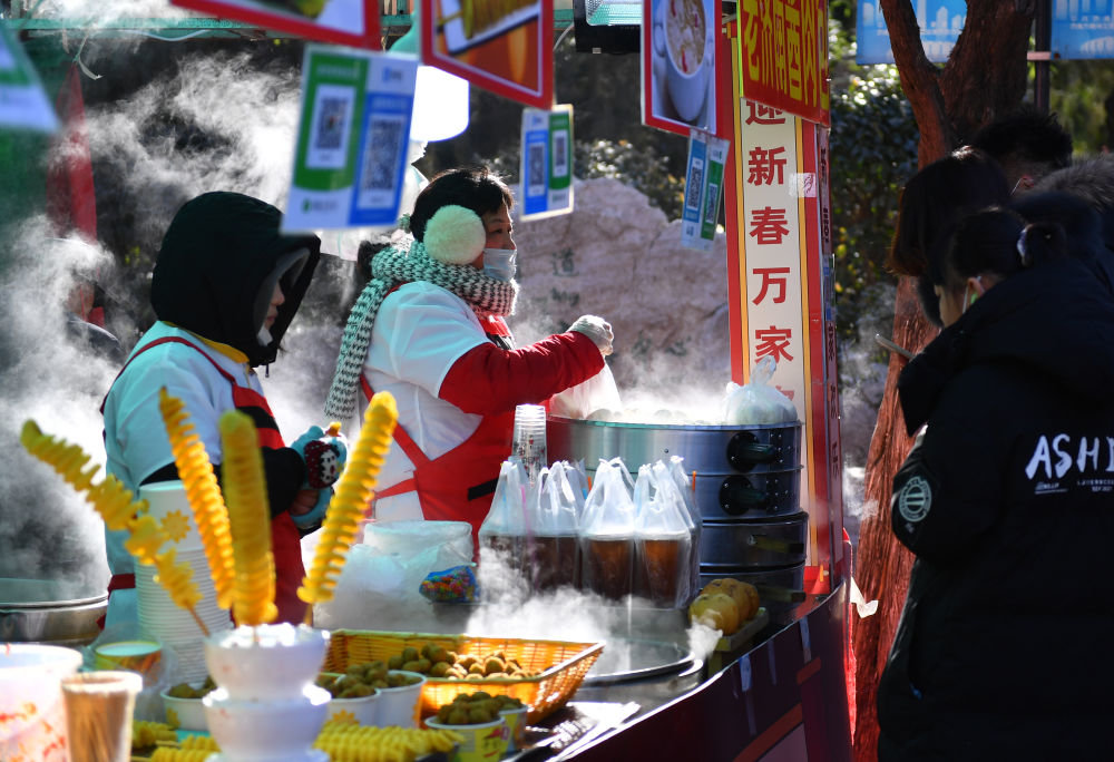 ↑1月25日，游客在济南千佛山新春游园会上选购美食。新华社记者 朱峥 摄