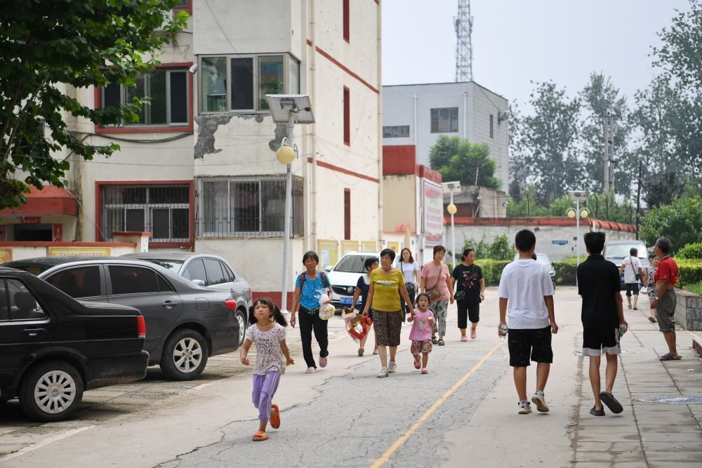 ↑8月3日，群众在涿州市第三中学安置点内行走。