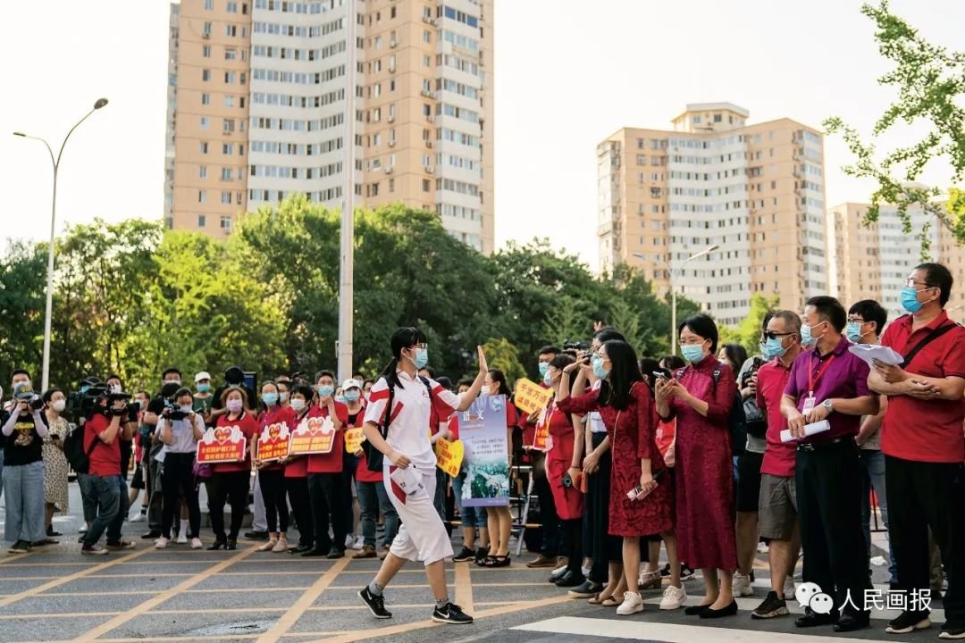 2020年7月,北京,人大附中考点外,一名考生入场前和老师隔空“击掌”。摄影 徐讯/人民画报