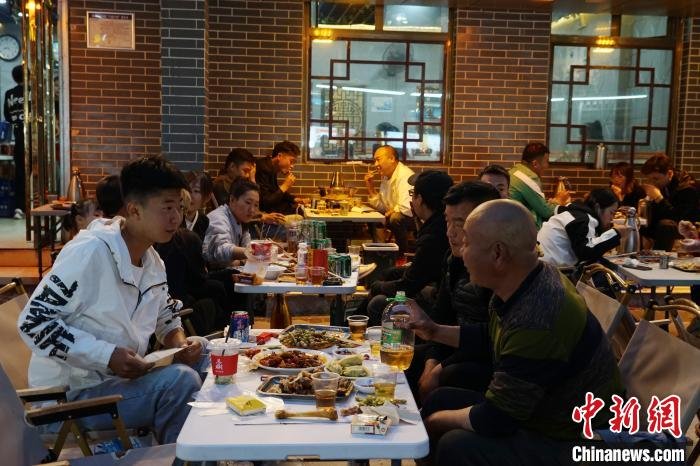 图为游客在西宁市城中区大新街夜市品尝青海特色美食。 马铭言 摄
