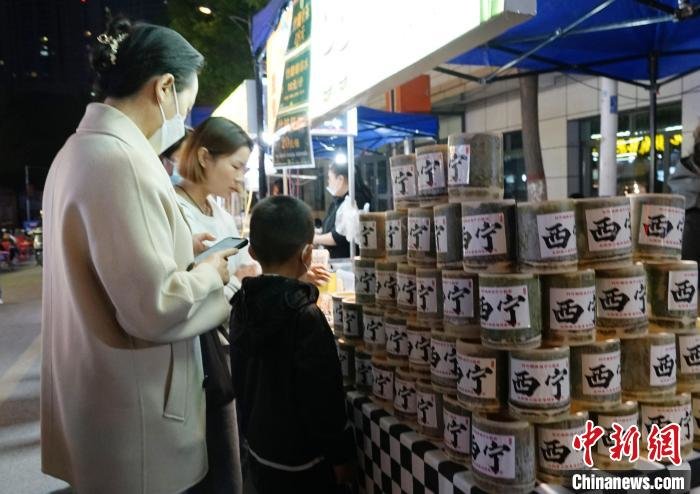 图为游客在西宁市城中区大新街夜市品尝特色饮品。 马铭言 摄