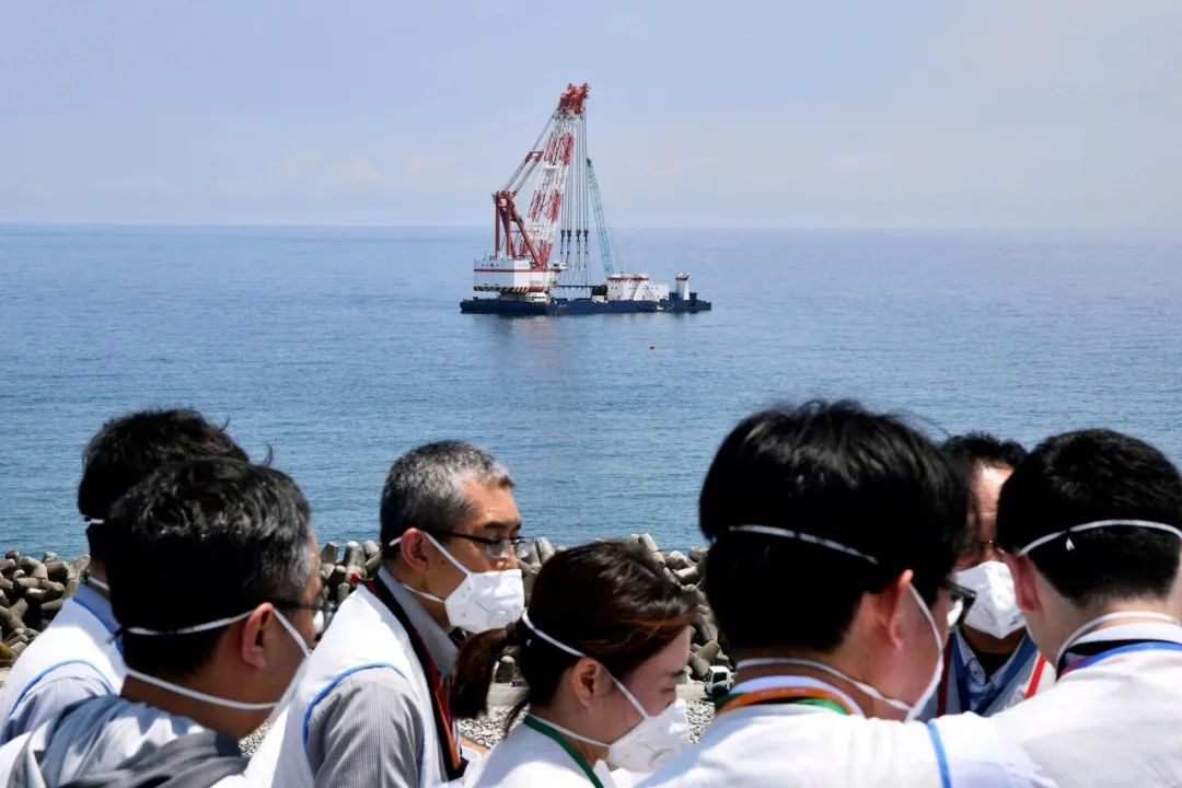 〓 2023年7月14日，东电公司发言人正在向参观福岛第一核电站的记者介绍核污染水排放计划。