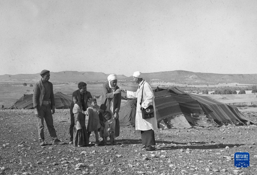 这张1965年的资料照片显示，中国援阿医生（右一）在阿尔及利亚赛伊达省为牧民诊治。新华社发（王南生 摄）