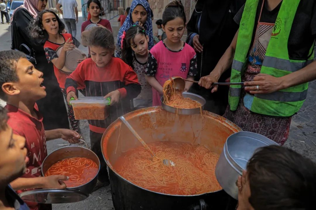 4月28日，在加沙地带南部城市拉法，巴勒斯坦儿童领取食物 图：新华社