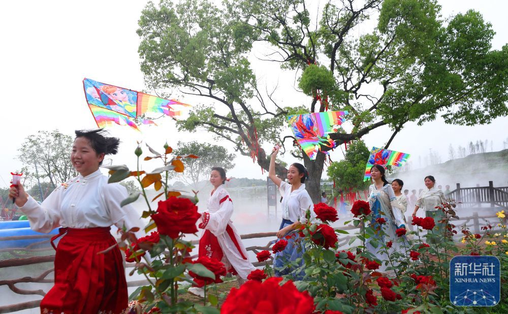 4月27日，在湖南省衡阳市珠晖区茶山坳镇，小朋友在金甲玫瑰花园里玩风筝。新华社发（曹正平摄）